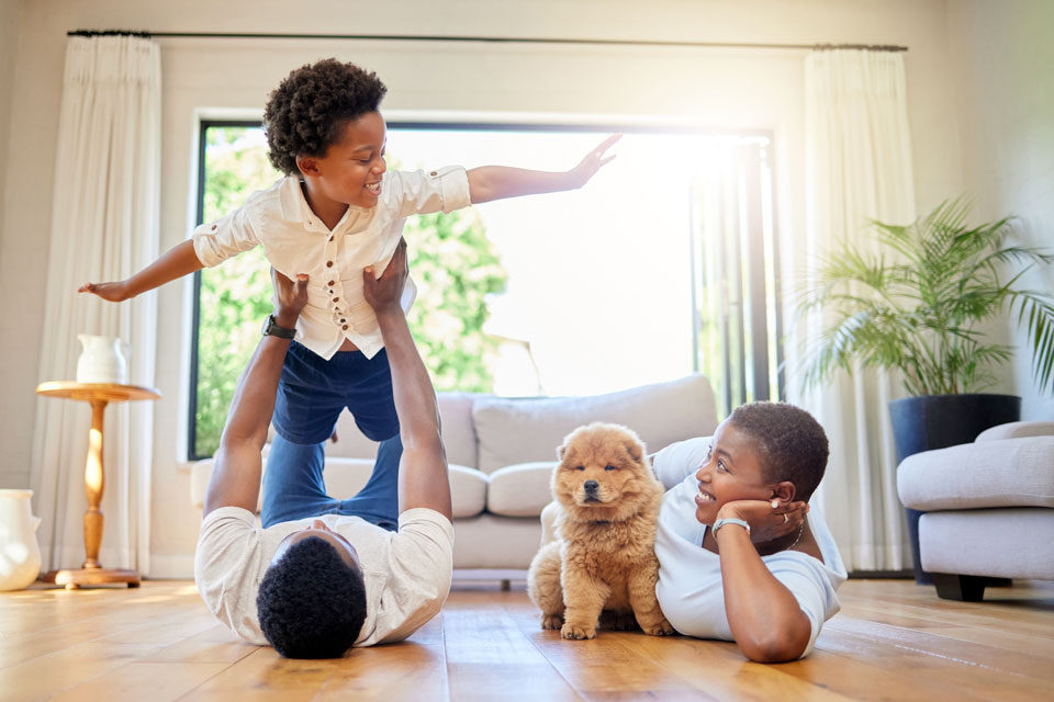 Family playing on the floor and holding a puppy