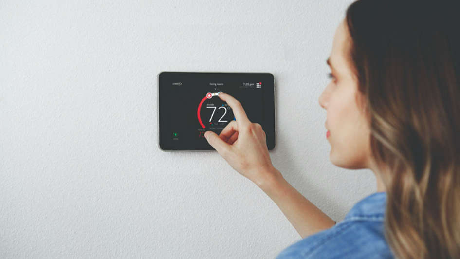 SEER 2 Woman adjust a thermostat